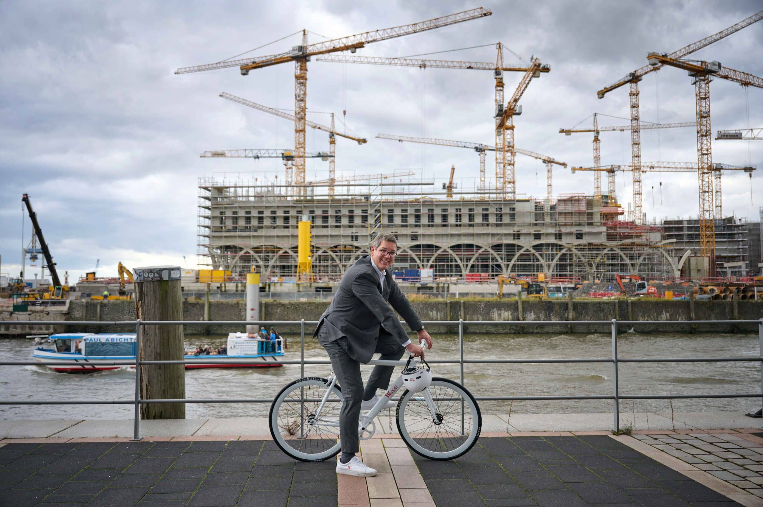 Fahrradfahre ohne Helm vor Baustelle Überseequartier